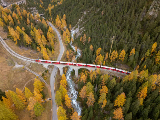 istock Red Train Crossing Bridge in Autumn Mountain Landscape 2181883695