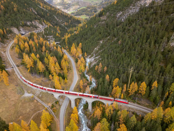 istock Red Train Crossing Bridge in Autumn Mountain Landscape 2181883697