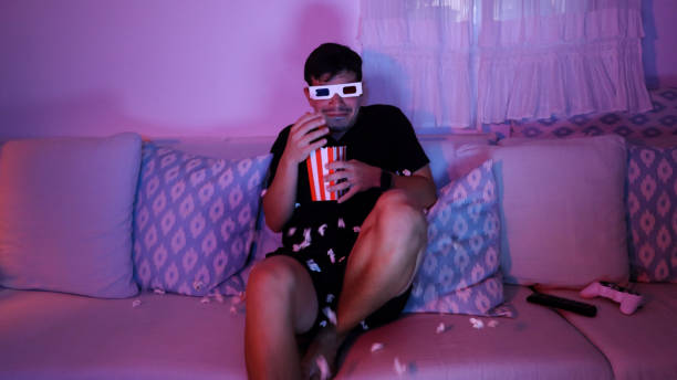 istock Scared man watching a movie with 3D glasses 2181885425
