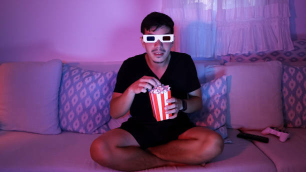 istock Young man eating popcorn with 3D glasses 2181885439