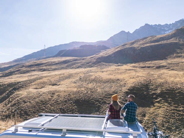 istock Couple Enjoying Mountain Views from Camper Van Roof 2181888369