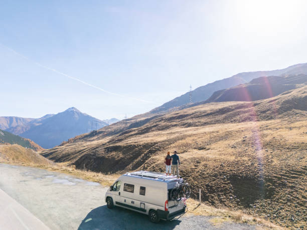 istock Couple Enjoying Scenic Mountain View from Camper Van Roof 2181888434