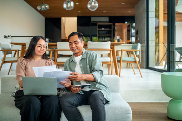 istock Happy Couple Reviewing Documents in Modern Home Interior 2181893438