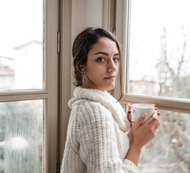 istock sad woman at the window 2181893894
