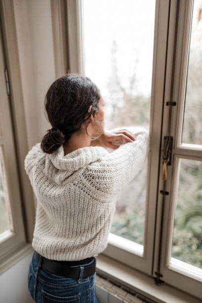 istock sad woman at the window 2181893981