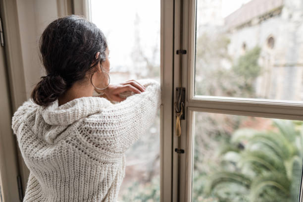 istock sad woman at the window 2181894210