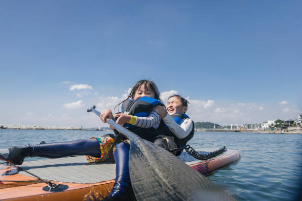 istock Asian siblings wearing life jacket playing  standup paddle boarding 2181894800