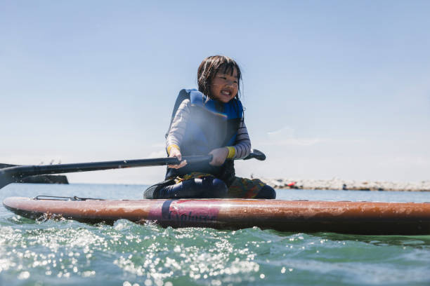 istock Asian girl playing standup paddle boarding 2181894828