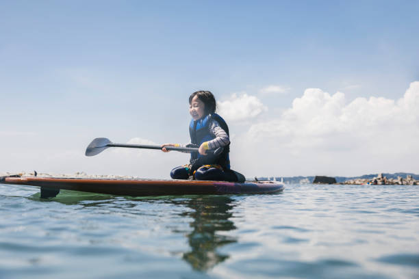 istock Asian girl playing standup paddle boarding 2181894833