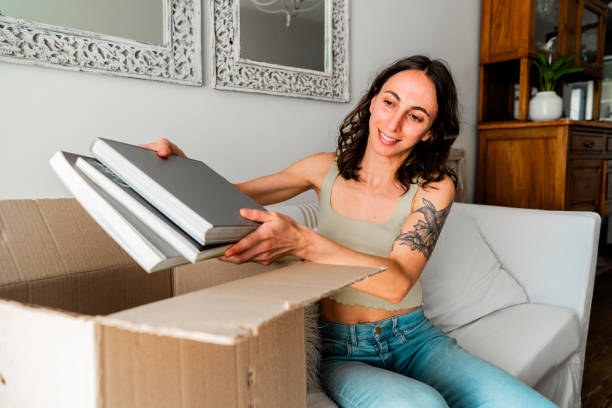 istock Young woman unpacking boxes at home 2181896532