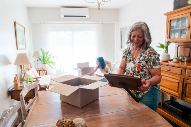 istock Senior woman looking picture frame during moving house 2181896942