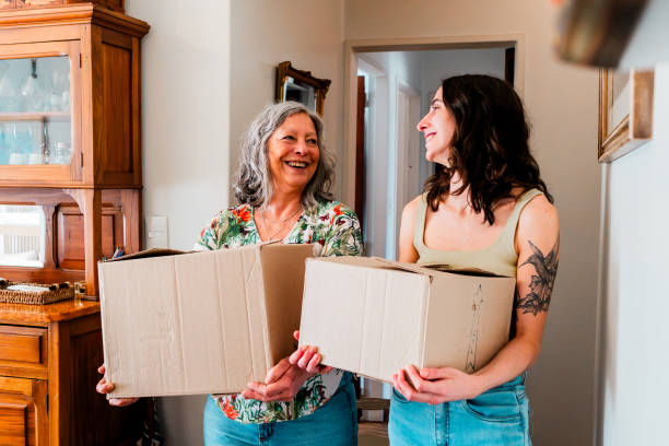 istock Mother and daughter talking and carrying boxes during moving house 2181897113