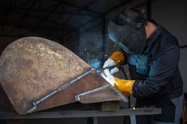 istock Metal worker welding metal part wearing protective gear 2181899701