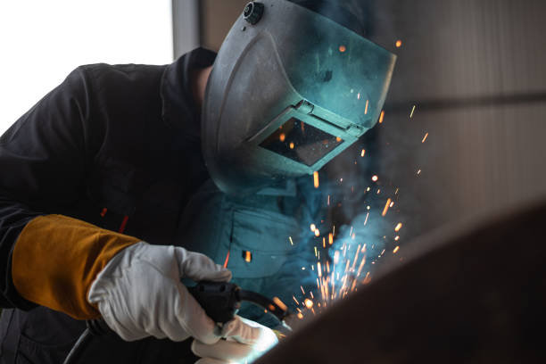 istock Worker welding metal with sparks flying in workshop 2181899704