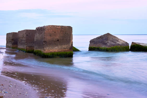 Big concrete blocks covered with algae in the sea
