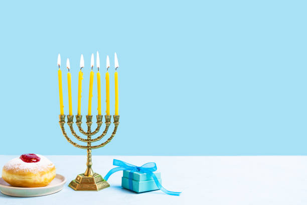 istock Hanukkah symbols: Menorah candles and sufganiyah jelly donuts 2181899911