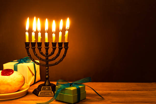 istock Hanukkah Menorah with burning candles and sufganiyah donuts 2181900002