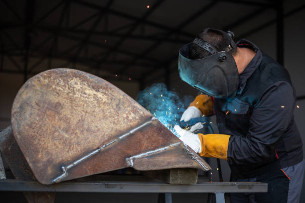 istock Metal worker welding steel part wearing protective gear 2181900077