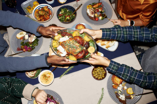 istock Male Hands Passing Cooked Turkey at Dining Table while Eating at Christmas Dinner 2181900374
