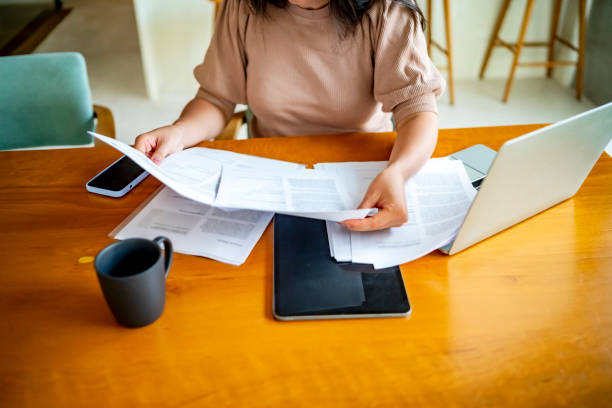 istock Woman Reviewing Documents at Home Office Desk 2181905669