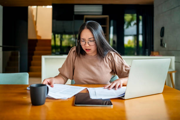 istock Stressed Woman Reviewing Documents at Home Office Desk 2181905682