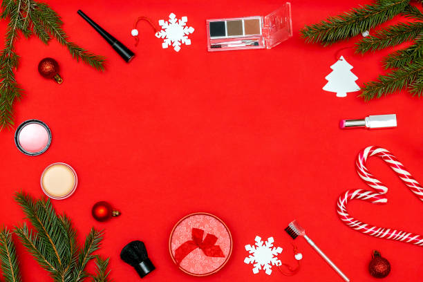 istock New year beauty cosmetics composition with brushes,lipstick,eyeshadow,powder,balls decorations,fir branches on red christmas background. Stylish fashion Flat lay frame, mock up, copy space,top view 2181906194