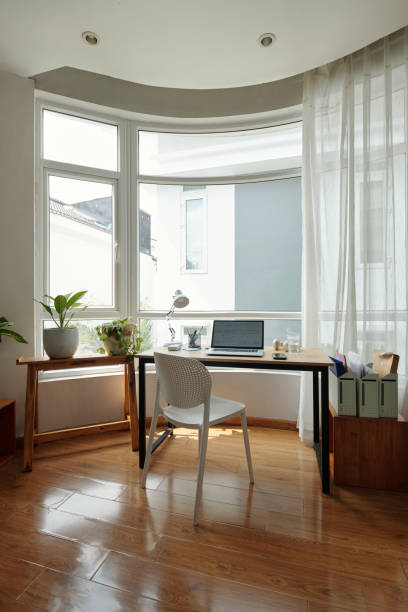 istock Sunlit Workspace Overlooking Garden with Wooden Flooring 2181907944