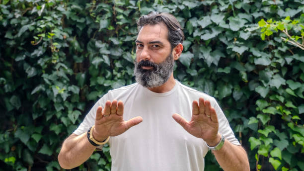 istock A middle-aged,  man with dark hair and a beard, looking at the camera and making a 