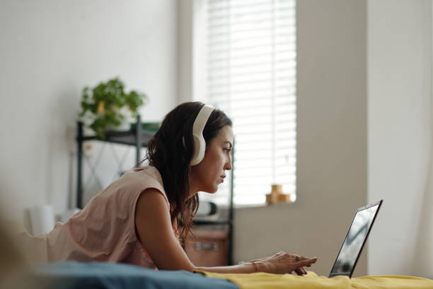 istock Listening to Music on Headphones While Working on Laptop 2181908836