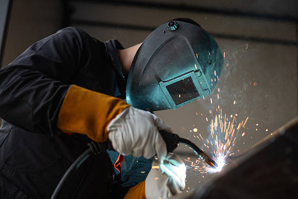 istock Metal worker welding steel with sparks flying in workshop 2181909019