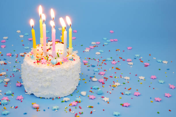 istock Birthday cake with burning candles on blue background 2181909448