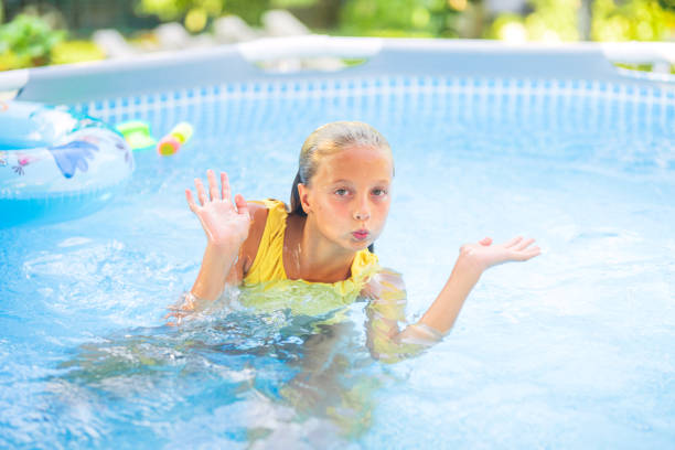 istock Girl making funny face is playing in swimming pool 2181914593