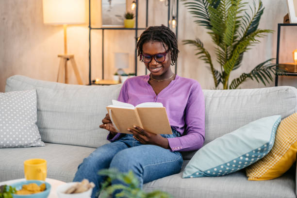istock Young Woman Reading A Book At Home 2181914673