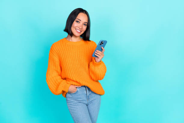 istock Photo of dreamy charming girl dressed orange pullover communicating modern gadget empty space isolated teal color background 2181921270
