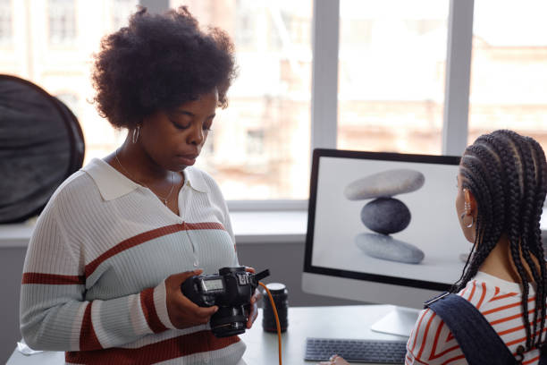 istock Young Black Woman Looking At Photos in Studio 2181930170