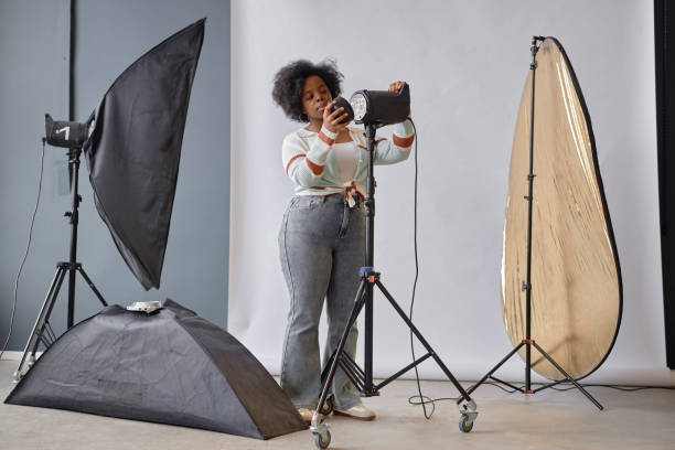 istock Black Woman Setting Up Lighting Equipment 2181930293