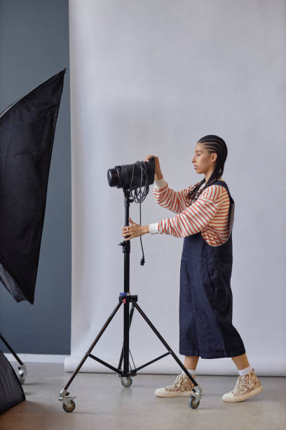 istock Female Photographer Setting Up Lighting Equipment 2181930306