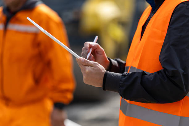 istock Construction site workers in safety vests reviewing plans during a project assessment in bright daylight 2181937869