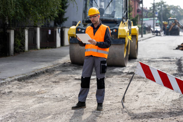 istock Construction worker inspecting road project with machinery and safety equipment on site in urban area during daylight 2181938445