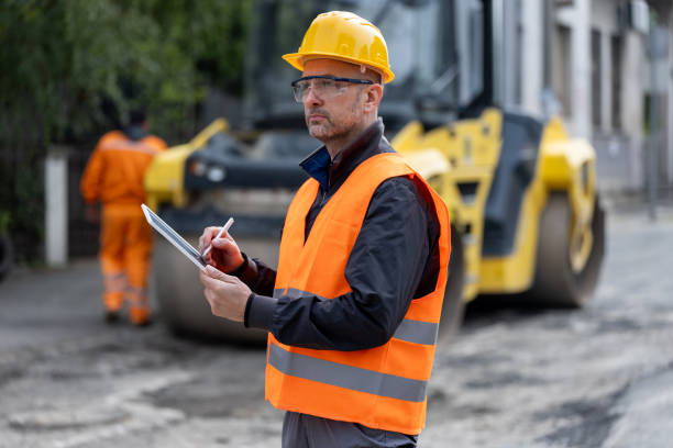 istock Construction worker assessing road conditions while wearing safety gear at a job site in broad daylight 2181938466