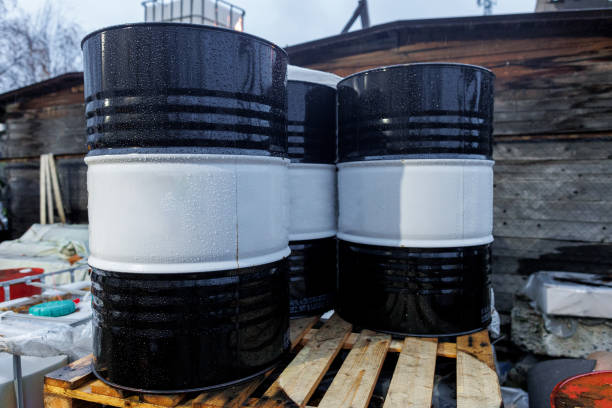Three sturdy barrels are carefully stacked one on top of the other on a solid wooden pallet, perfectly arranged for storage
