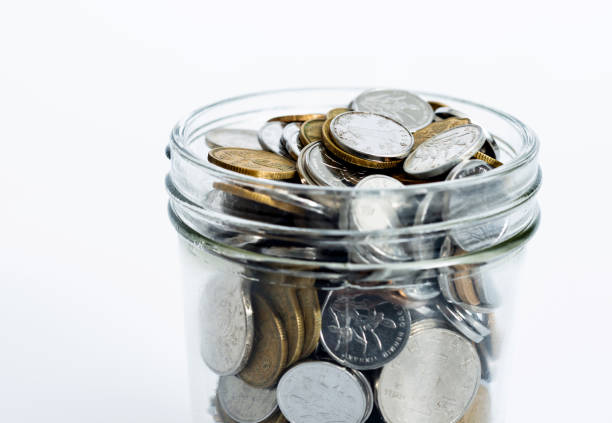 istock Glass jar full of coins on white background 2181944314