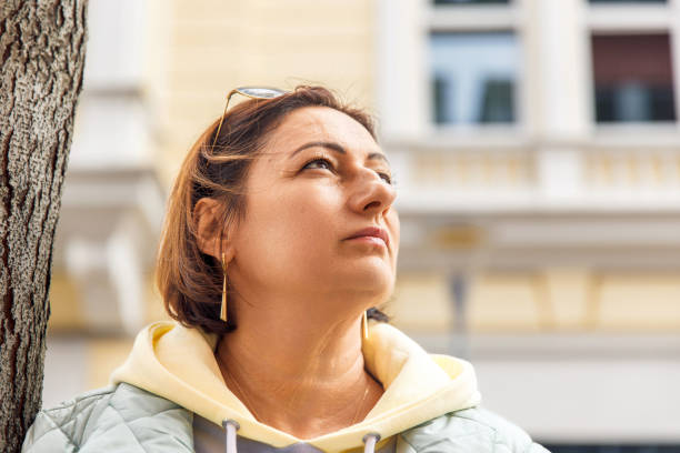 istock Thoughtful woman outdoors looking up at urban building background 2181944448