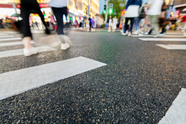 Motion blurred people walking on crosswalk.