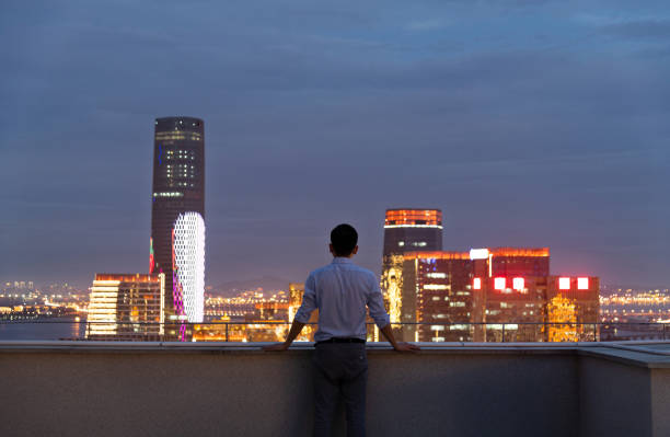 istock Businessman looking at cityscape on the rooftop 2181944525