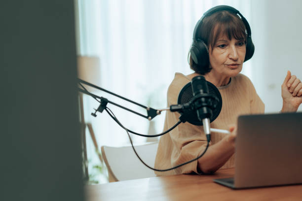istock Professional Podcast Host in Action: Senior Woman Using Quality Equipment in Modern Studio 2181950616
