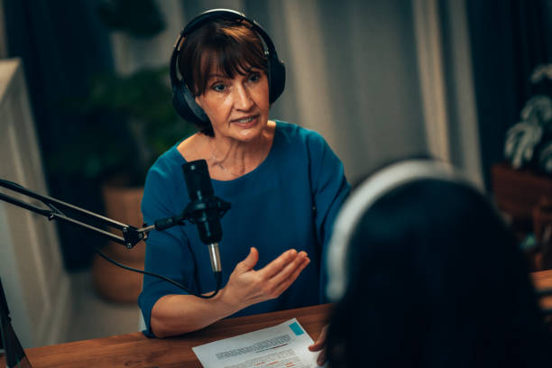 istock Senior Female Podcaster in Conversation: Engaging Host in Modern Studio 2181950718