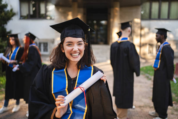 istock Excited student celebrating graduation outdoors with classmates on a sunny day 2181952347