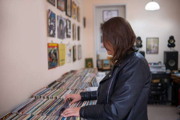 istock Record shops. A woman in a black leather jacket in a record store. 2181953466