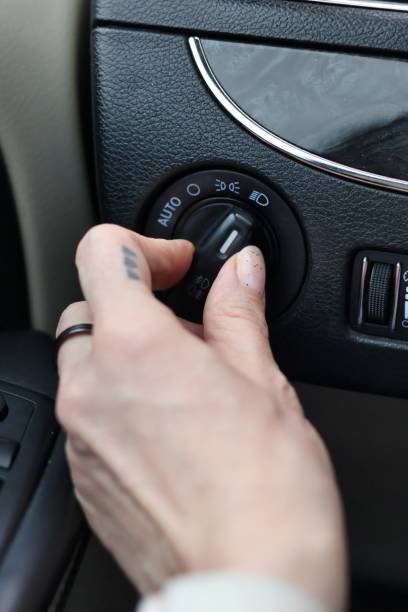 istock Low beam headlights - hand turning on the lights in the car 2181954222